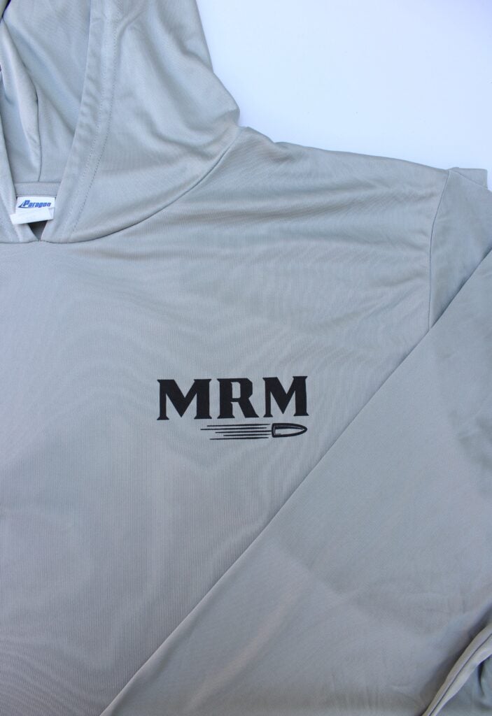 Gray jacket with the bold 'MRM' logo and a small pen sketch on the fabric label area.