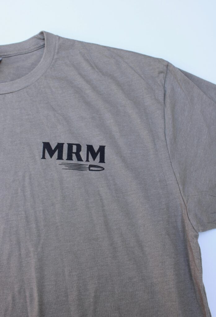 Grey t-shirt laid flat showing a black 'MRM' logo with a small underline/graphic beneath it.